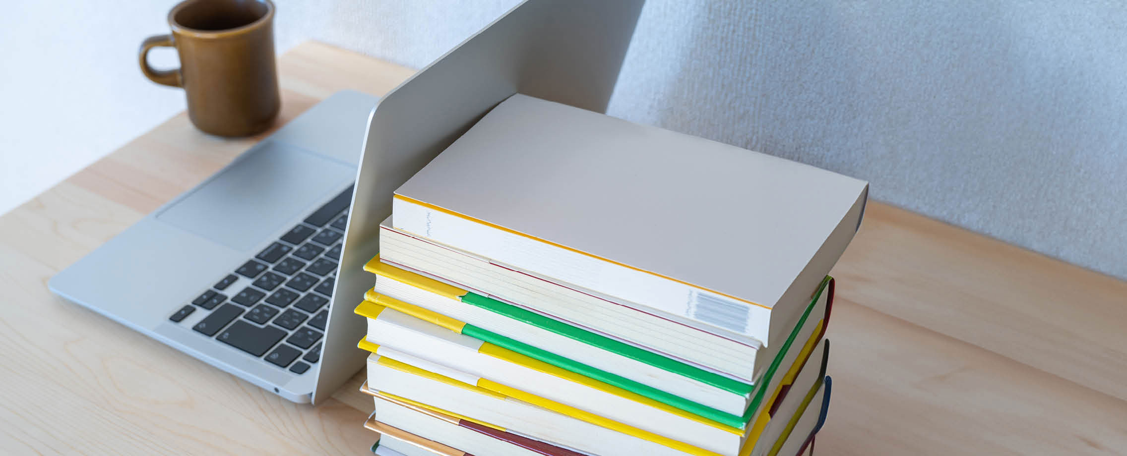 Photo d'un ordinateur portable à côté d'une pile de livres