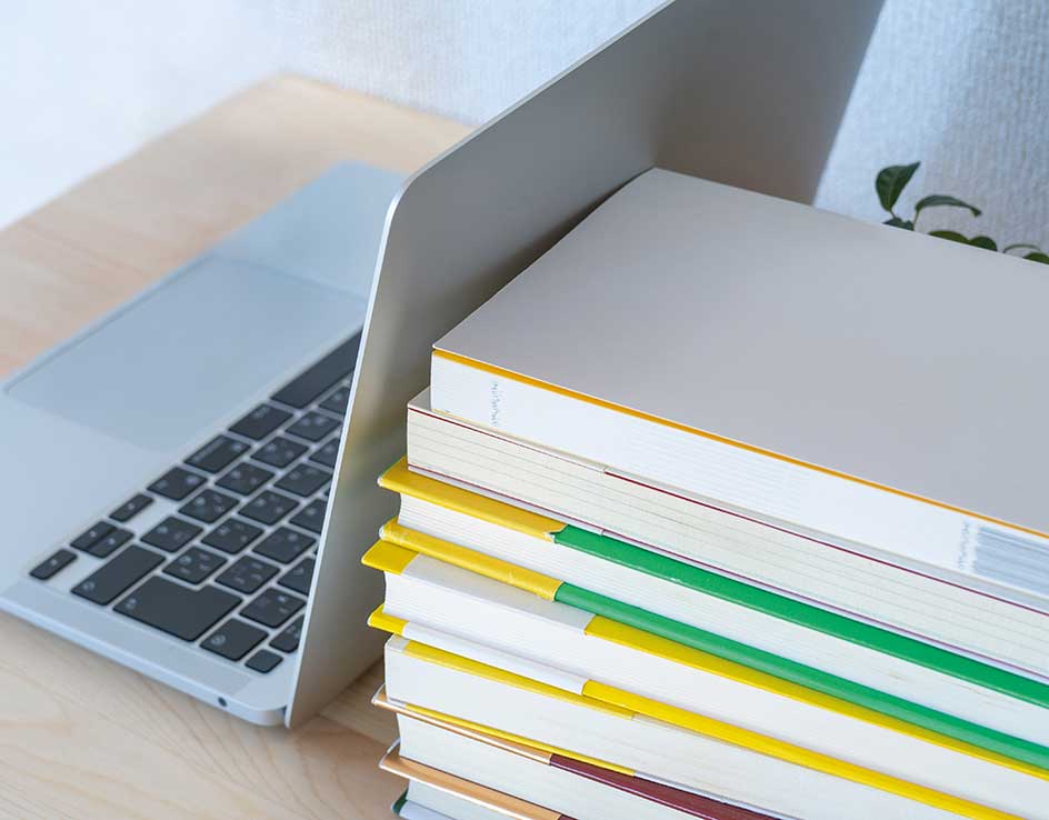 Photo d'un ordinateur portable à côté d'une pile de livres