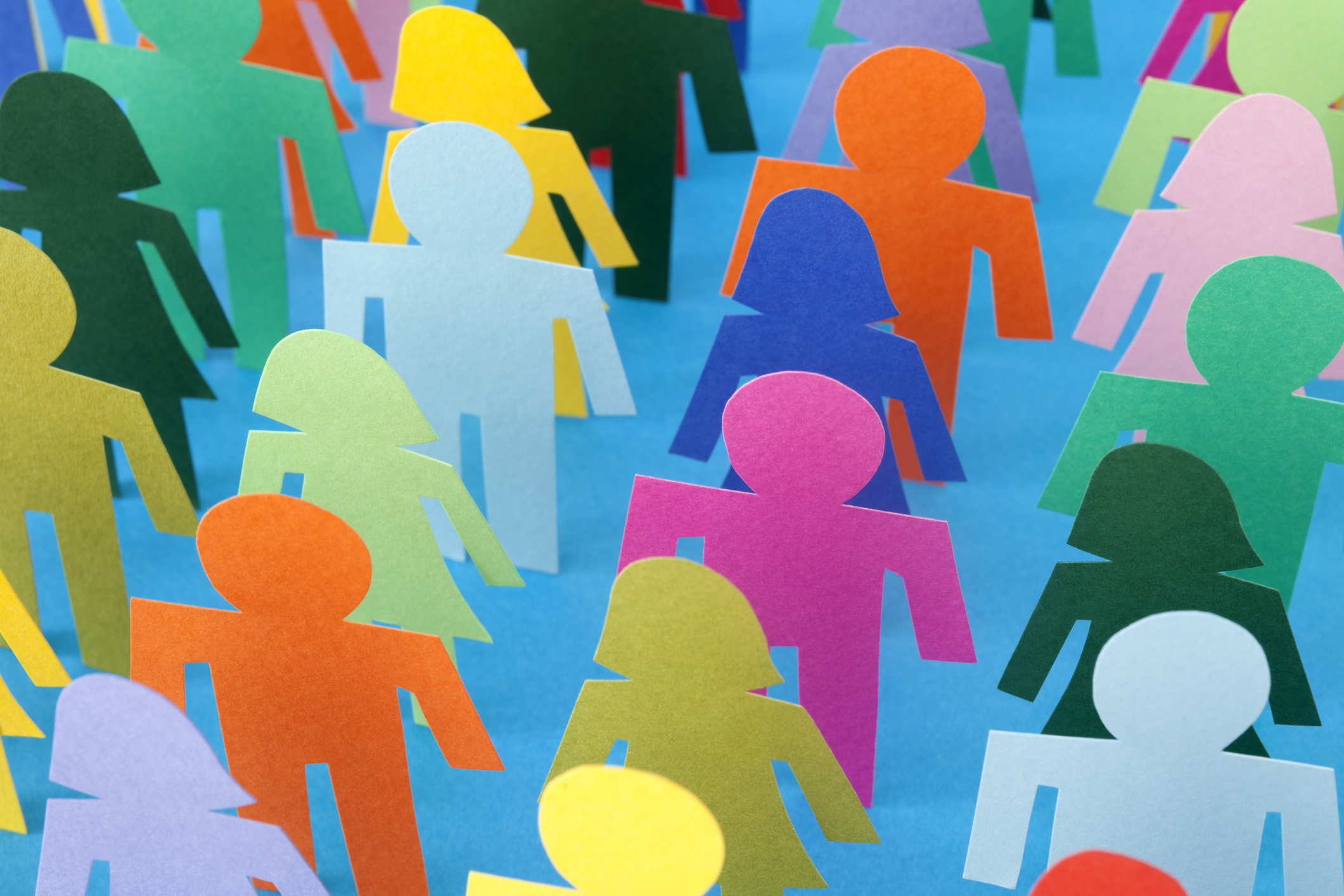 Figures de femmes et d'hommes en papier se tenant en rangée, un à côté de l'autre.