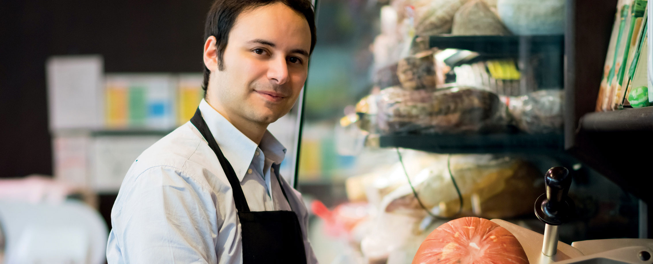 Homme travaillant dans la charcuterie au supermarché.
